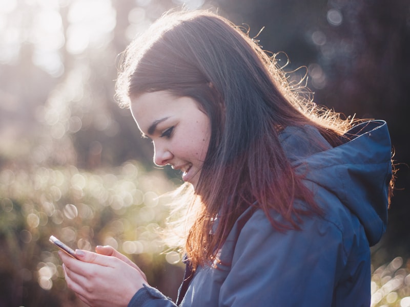 Woman smiling while sharing a product link on her phone